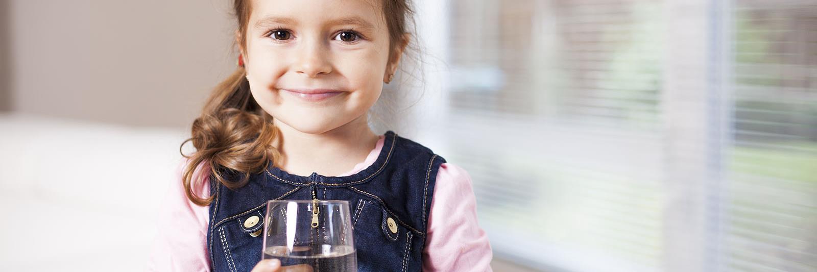 young-girl-holding-glass-of-water-facing-camera_web_1600x1067_color