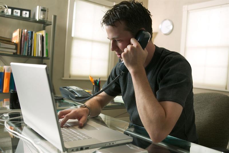 man-speaking-on-phone-typing-on-computer_web_1600x1067_color