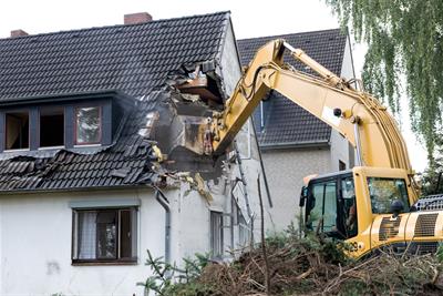 Backhoe Demolishing Home Roof