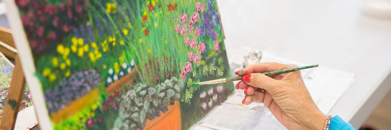 senior-woman-hand-painting-in-art-class-1600x533