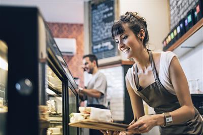 owner getting food display ready for clients at coffee shop