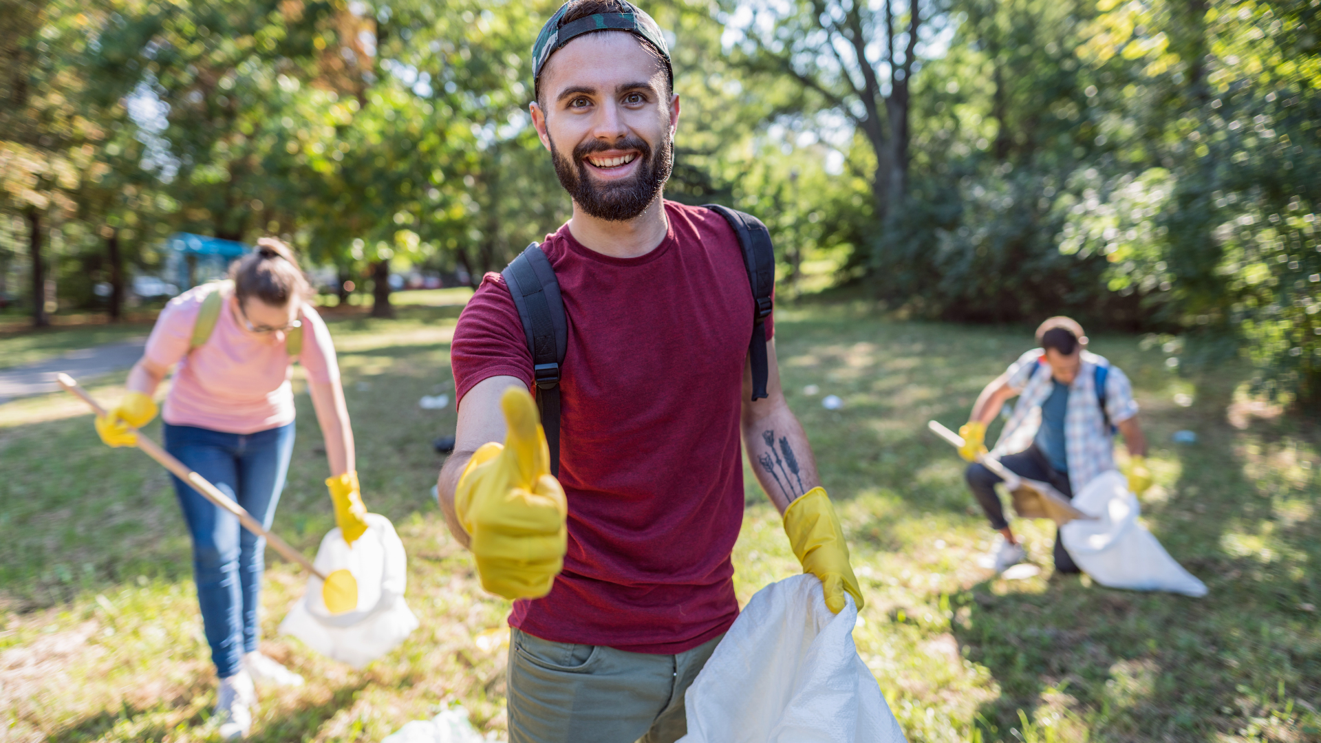 Three volunteers at park cleaning.