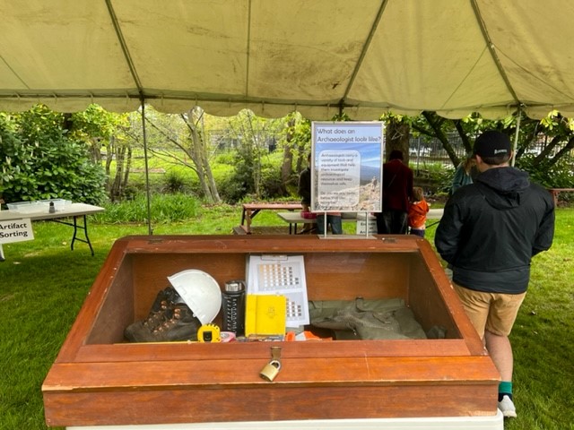 Public archaeology project open house features displays under cover.