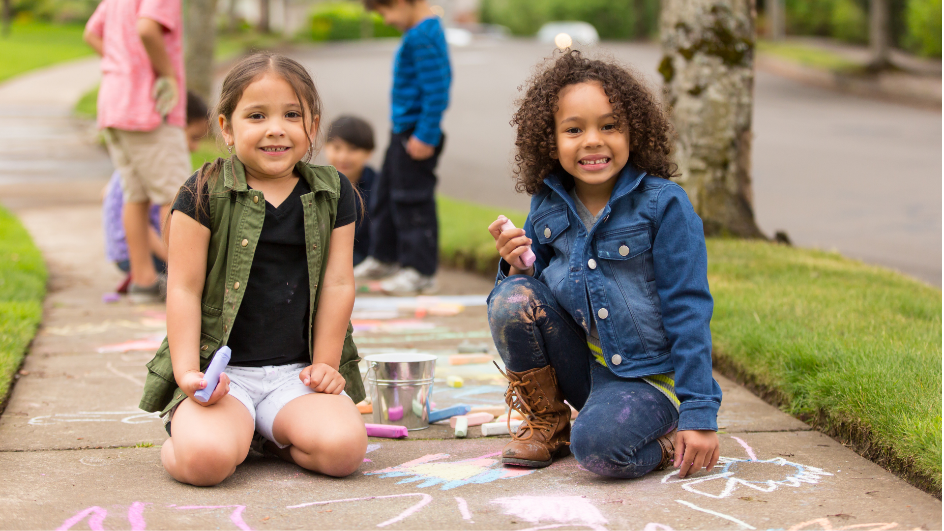 Kids playing with chalk on sidewalk