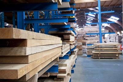 stacked lumber in warehouse awaiting construction