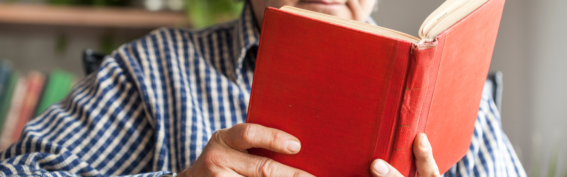 Person in plaid shirt reading a book