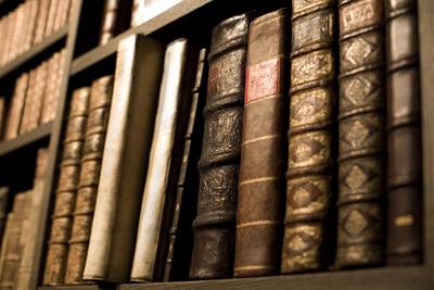 old leather bound books on bookshelf