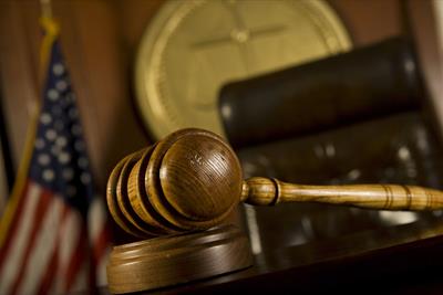 gavel in courtroom closup with american flag in background