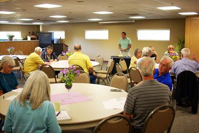 group of people gather at a neighborhood association meeting