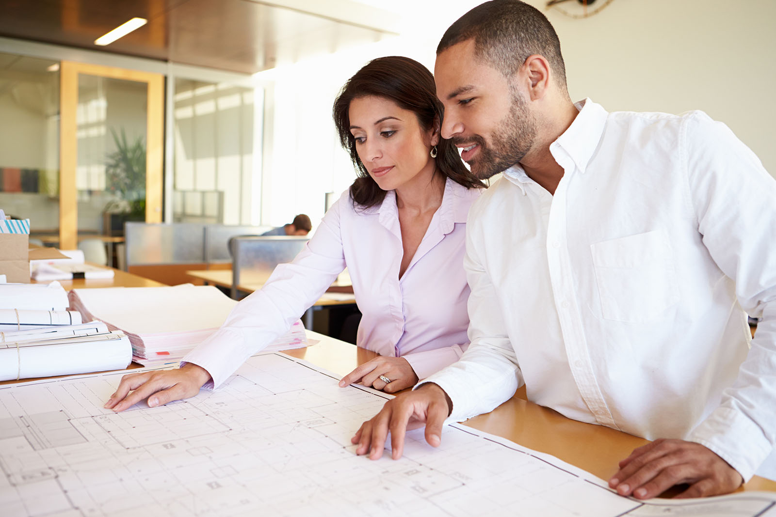 architects studying plans in modern office together