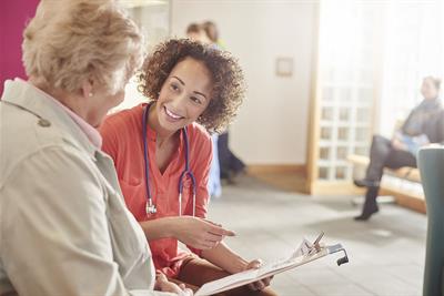 doctor speaks to elderly patient in waiting room