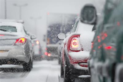 cars driving on highway stuck in traffic because of snow storm